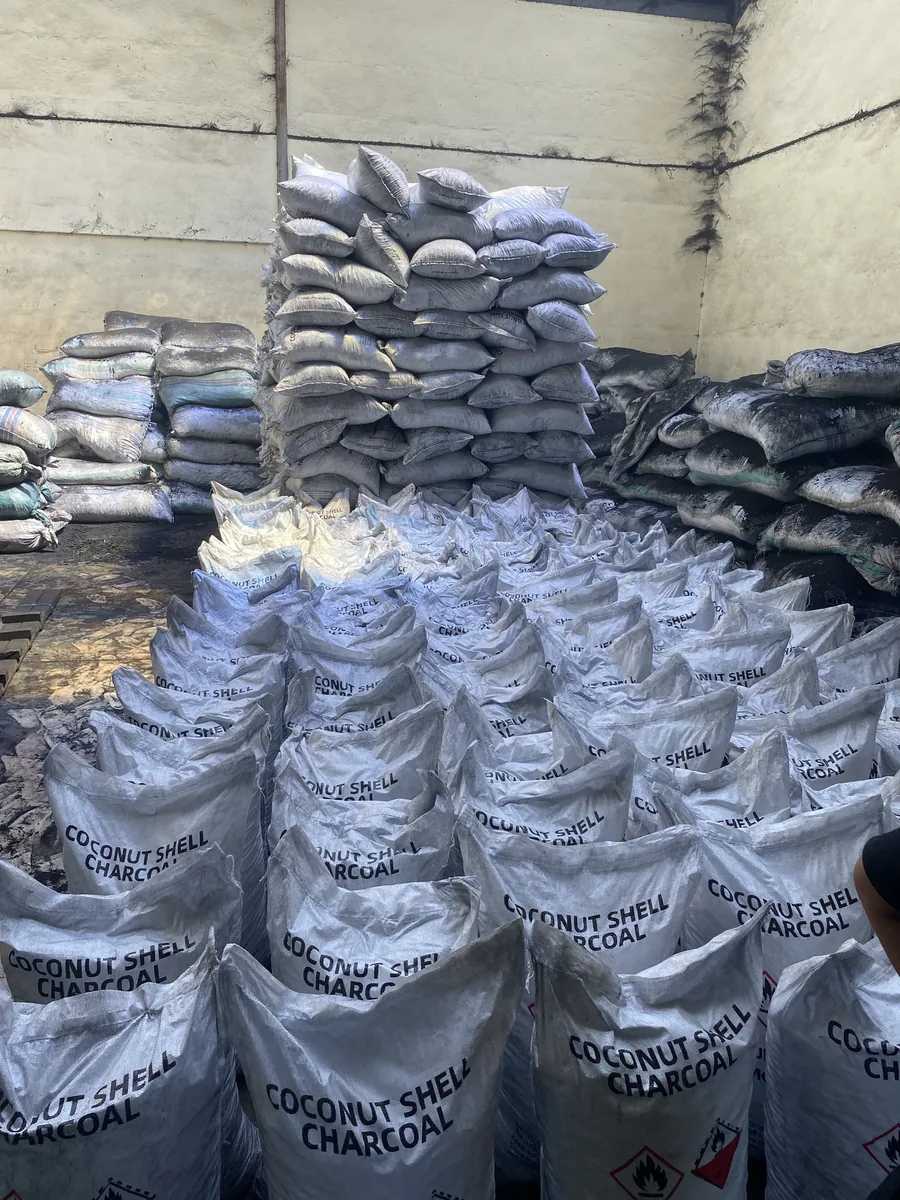 Sacks of coconut shell charcoal in a warehouse