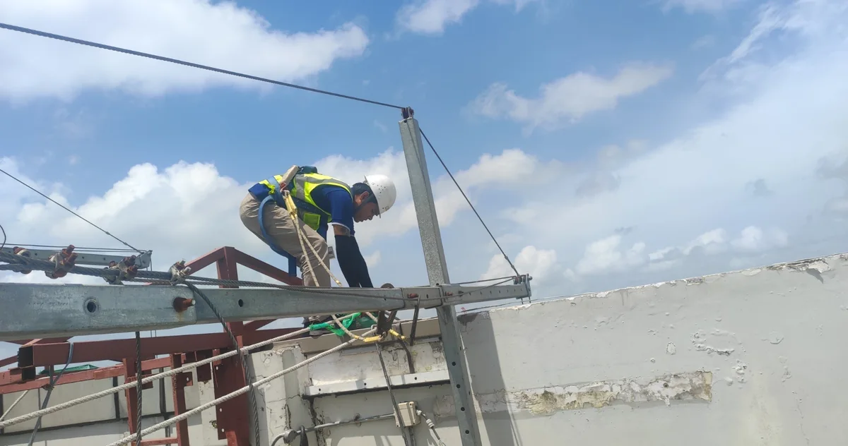 Worker installing a roof suspension component